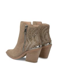 Botines de ante beige hasta el tobillo con cremalleras laterales, patrones de tachuelas y un tacón apilado con un acabado texturizado. Los acentos incluyen detalles metálicos.