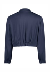 Veste courte bleu marine en tissu lisse. Manches longues avec des poignets élastiques et une taille froncée. Design de col classique.