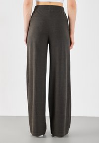 Braune gerippte weit geschnittene Hose aus weichem Stoff, mit hohem Bund und entspanntem Schnitt, was für Komfort und Vielseitigkeit spricht.