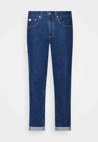 Mörkblå denimjeans med slim fit, har fem fickor, knappstängning och uppvikta nederkanter. Slät textur, diskret stickningsdetalj.