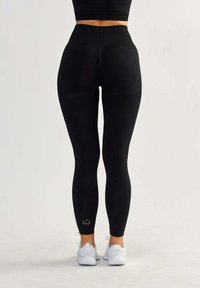 Leggings neri a vita alta con un design a coste testurizzate, caratterizzati da un piccolo logo a forma di cuore all'orlo e una vestibilità aderente.