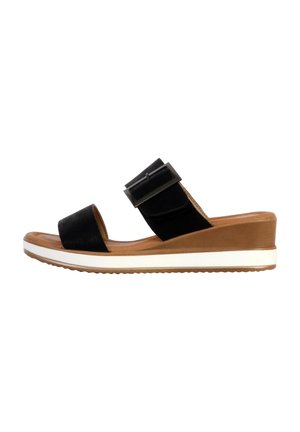 Sandale noire à talon compensé avec deux lanières : une en cuir lisse, l'autre avec une boucle noire. Présente une semelle marron avec une bande blanche et beige.