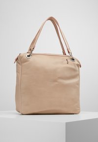 Beżowa skórzana torba tote o gładkiej fakturze, podwójnych ramiączkach, akcentach ze srebrnym okuciem i prostokątnym kształcie.