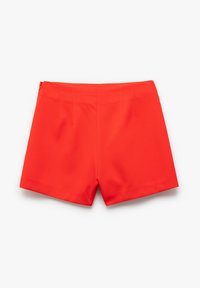 Rode shorts gemaakt van lichtgewicht materiaal met een gladde textuur. Beschikt over riemlussen, plooien en een ritsluiting; de zoom eindigt boven de dij.