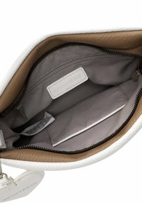 Sac en cuir blanc avec un intérieur en cuir marron. Comprend un compartiment zippé, une doublure grise et une petite étiquette blanche à l'intérieur.