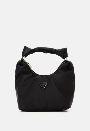 Zwarte zachte stoffen handtas met gedraaide handgreep, gouden rits en driehoekig Guess-logo aan de voorkant, tegen een effen witte achtergrond.