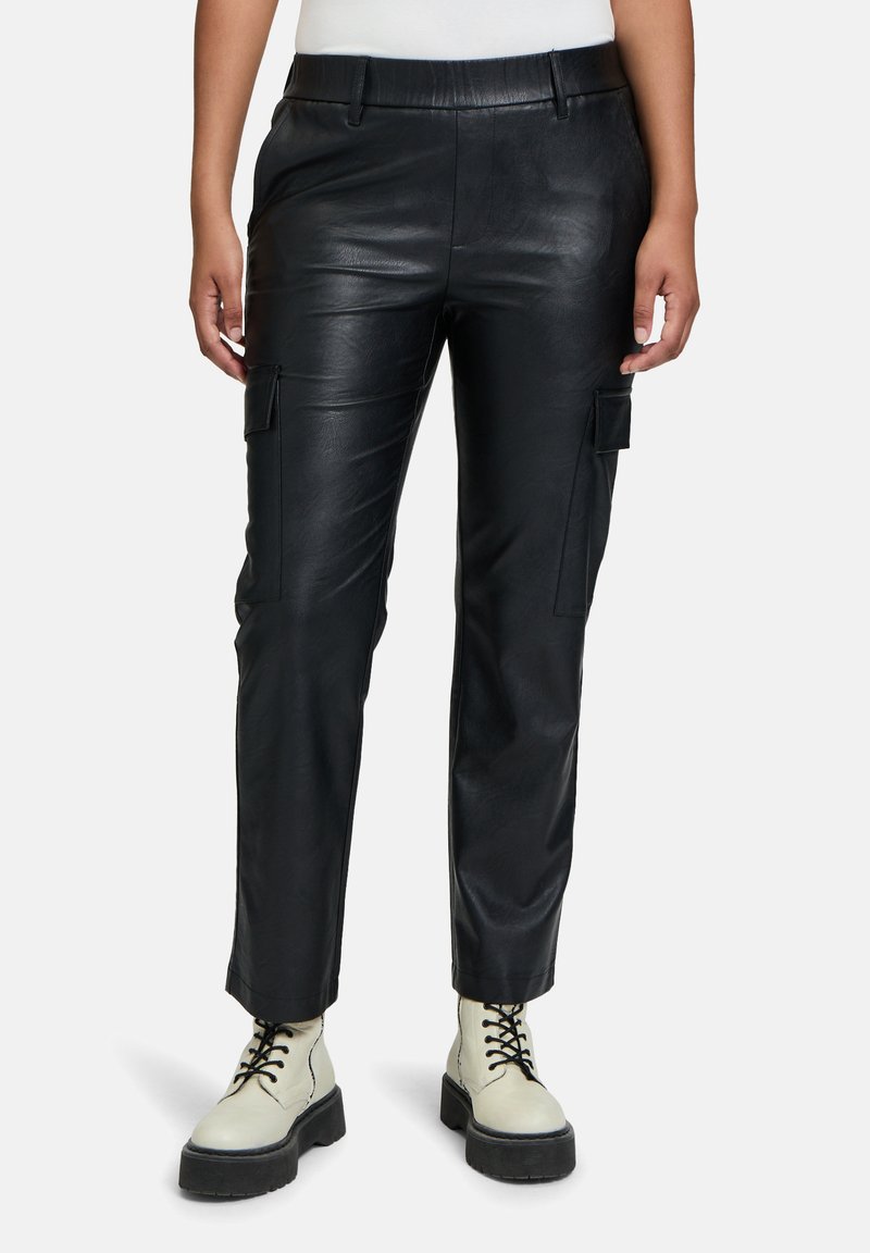 Zwarte leren cargobroek met een aansluitend ontwerp, voorzien van zijzakken en een gladde textuur, gecombineerd met chunky crèmekleurige laarzen.