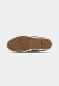 Shoe sole featuring a textured brown rubber material with a diamond pattern and white surrounding edge, designed for grip and durability.