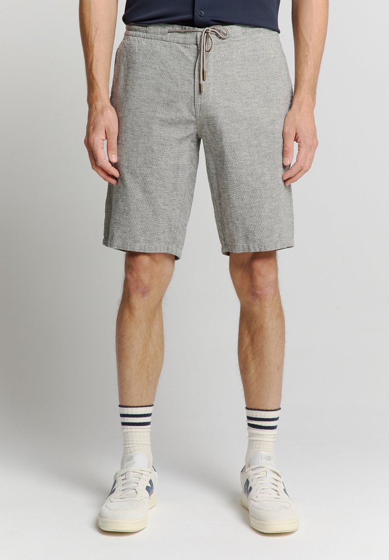 Gray sports shorts with a drawstring waistband, featuring a textured fabric. Paired with white sneakers and striped crew socks.