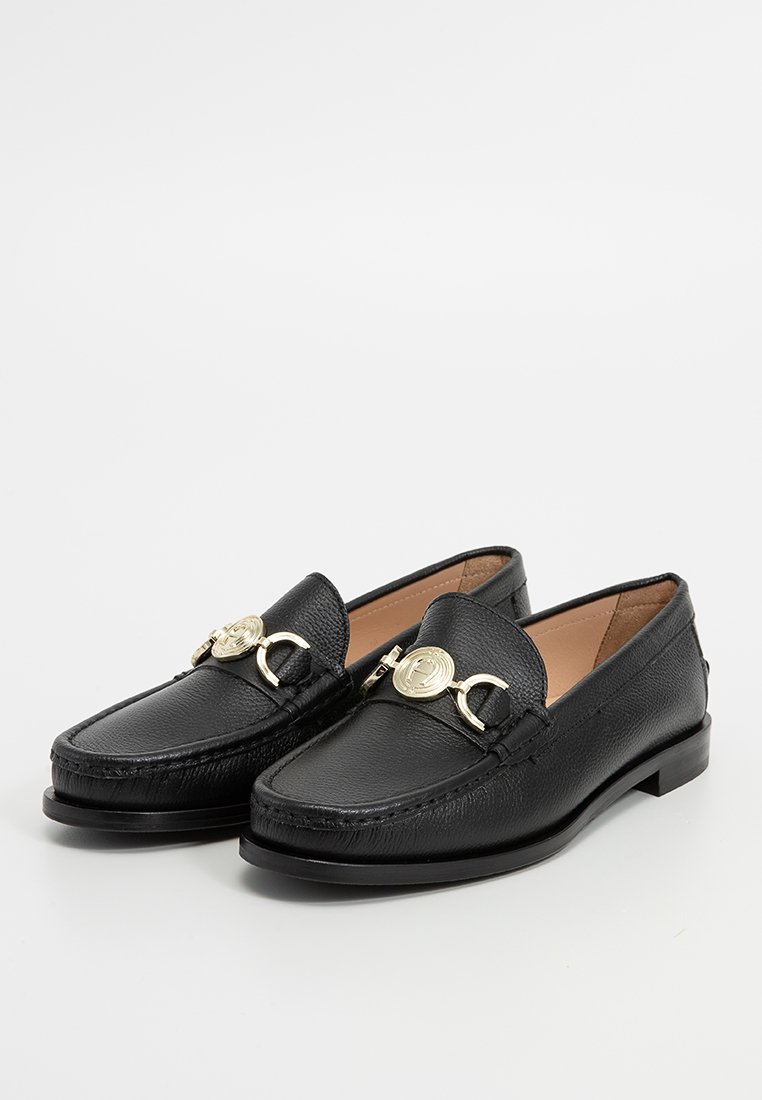 Czarne skórzane mokasyny o teksturowanym wykończeniu, z złotym okrągłym akcentem na przodzie. Płaska podeszwa, klasyczny design.