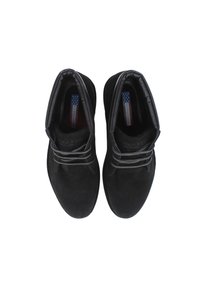 Botines de ante negros con punteras redondas, cordones grises en contraste, cuello acolchado y logo visible en el interior. Superficie texturizada y diseño sencillo.