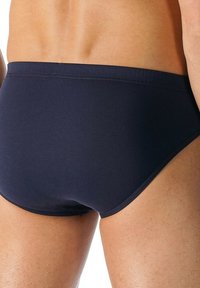 Marina simbyxor i navy med en mjuk, stretchig struktur och en enkel design, elastisk midja och minimalistisk klippning.