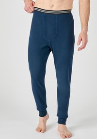 Leggings térmicos de color navy con un diseño ajustado, que cuentan con una cinturilla elástica a rayas y puños acanalados, fabricados con un material suave y elástico.