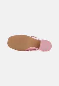 Roza slip-on čevlja z gladko površino, gumijastim podplatom in zaobljenim prstom. Ima teksturirano podlago za boljši oprijem.