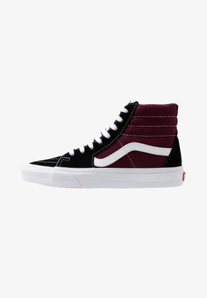 Baskets montantes avec bout en daim noir et lacets, côté textile bordeaux, bande ondulée blanche et semelle en caoutchouc blanche.