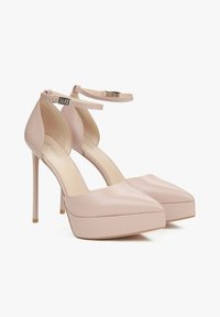 Pink high-heeled shoes with a smooth finish, pointed toe, platform front, thin ankle strap, and metal buckle detail.