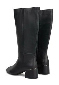 Botas de cuero negro hasta la rodilla con un tacón cuadrado, que presentan un acabado suave, costuras verticales y un acento metálico en el tacón.