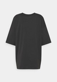 Camiseta negra de gran tamaño con mangas cortas, escote redondo y textura suave. La vista trasera muestra un diseño simple sin adornos.