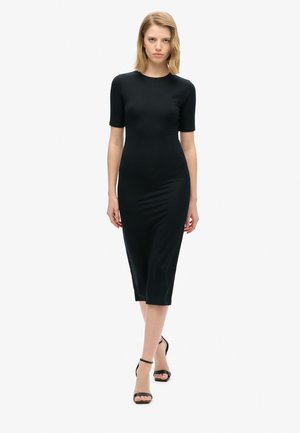 Black, form-fitting midi dress with short sleeves and round neckline, made of smooth fabric, paired with black strappy heels.
