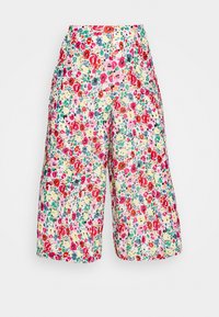 Culottes fleuries avec un motif vibrant de rouge, rose, jaune et vert sur fond blanc, dotées d'une taille haute et d'une coupe à jambes larges.