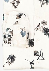 Weißes Langarmhemd mit floralem Muster in Schwarz und Blau, mit umklappbarem Kragen und Knopfverschluss. Hergestellt aus weichem, strukturiertem Stoff.