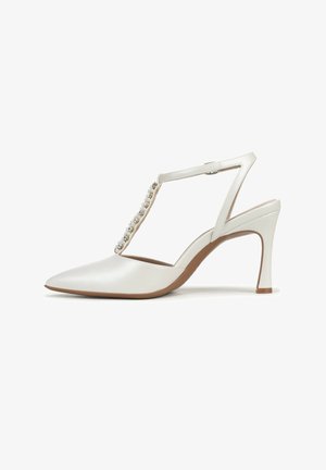 White leather high-heeled shoe with pointed toe, adjustable strap, and decorative beading along the front, set on a tapered heel.