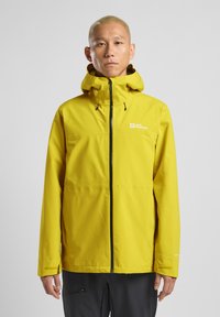 Giacca impermeabile gialla con cappuccio, zip frontale, dettagli neri e logo. Tessuto liscio e leggero, progettata per attività all'aperto.
