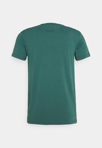 T-shirt a maniche corte di colore verde scuro, realizzato in tessuto morbido. Presenta un classico colletto rotondo e orli semplici cuciti. Senza grafiche o motivi.