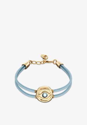 Bracelet en cuir bleu avec ferrures en métal doré et un motif central en forme d'œil orné d'une pierre précieuse bleu clair. Deux lanières flexibles.