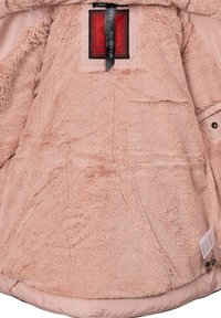Intérieur de veste rose clair avec une texture douce et pelucheuse et une doublure lisse. Présente une étiquette avec une marque et un petit détail de logo près de l'ourlet.