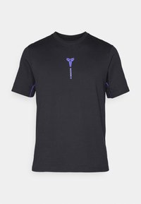 Zwart katoenen T-shirt met een klein paars FC Barcelona-logo op de voorkant en paarse accenten op de mouwen. Ronde halsontwerp.