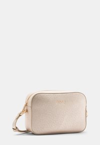 Borsa a tracolla rettangolare beige con superficie testurizzata, accessori in oro e chiusura con zip. Presenta una tracolla laterale e un logo impresso sul davanti.