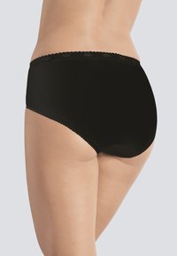 Perizoma nero a vita alta con texture liscia, bordi ondulati in vita e vestibilità aderente, parzialmente coperto dal tono della pelle.