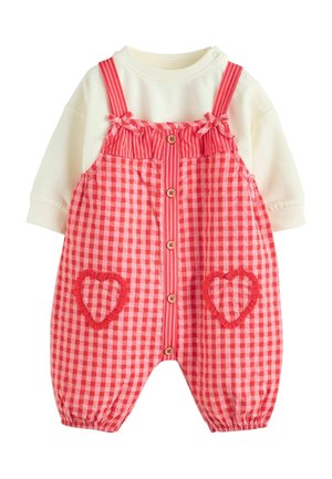 Rot-weißer Karomuster-Spielanzug mit herzförmigen Taschen, elastischen Manschetten und Holzknöpfen. Darunter ein weißes Langarmshirt.