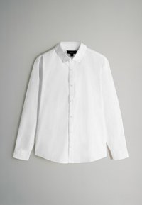 Balta garām piedurknēm spiedpogājamā krekla uzvalkā, kas izgatavots no auduma ar struktūru, ar norādītu apkakli, taisnu apakšmalu un standarta spiedpogām.