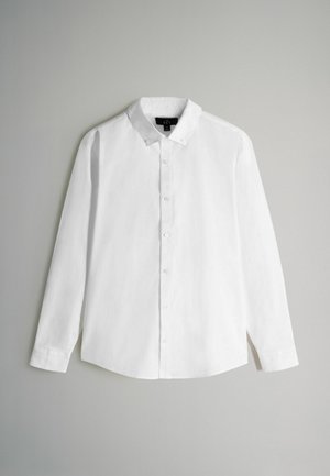 Camisa blanca de manga larga y botones hecha de tela tejida con un collar puntiagudo, que presenta un dobladillo recto y cierre de botones estándar.