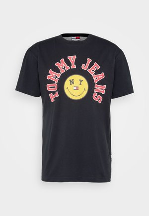 T-shirt en coton noir avec un grand visage souriant jaune et le texte rouge "TOMMY JEANS NY". Manches courtes et col rond.