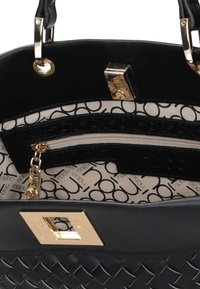 Czarna pleciona torebka z złotym zapięciem, podwójnymi uchwytami oraz wewnętrzną kieszenią na zamek wyłożoną beżowym materiałem z czarnym nadrukiem.