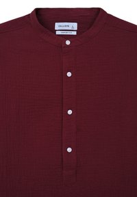 Maglietta a maniche lunghe color marrone scuro con colletto tondo e bottoni bianchi sul davanti, etichettata Calliope, taglia grande, vestibilità comoda.
