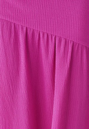 Tessuto strutturato di un vivace rosa acceso, con dettagli arricciati e una sezione superiore liscia. Il materiale sembra leggero e leggermente stropicciato.