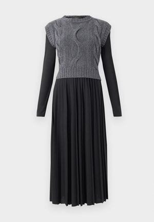 Robe pull avec un buste en jersey gris à empiècements en côtes et une jupe plissée noire. Présente des manches courtes et un col rond. Design long et fluide.