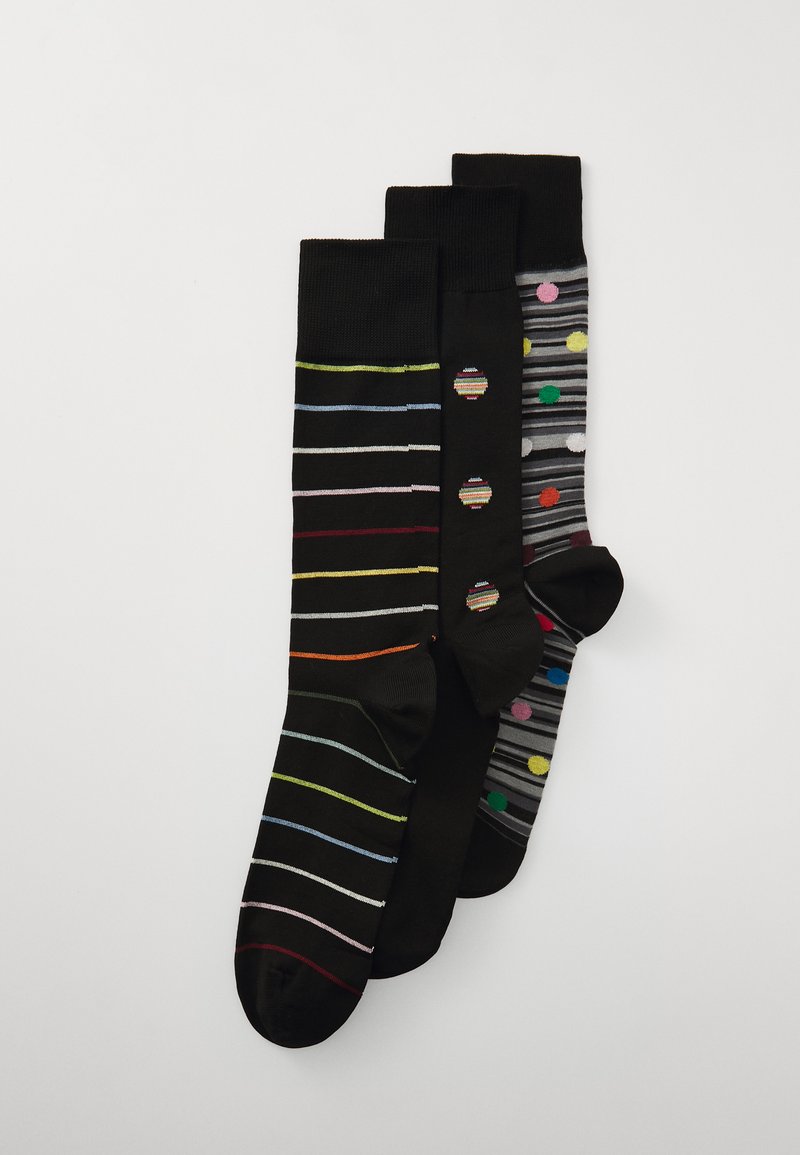 Tre paia di calzini: uno con strisce colorate su sfondo nero, uno con pois grigi e uno con linee sottili di vari colori su sfondo nero.