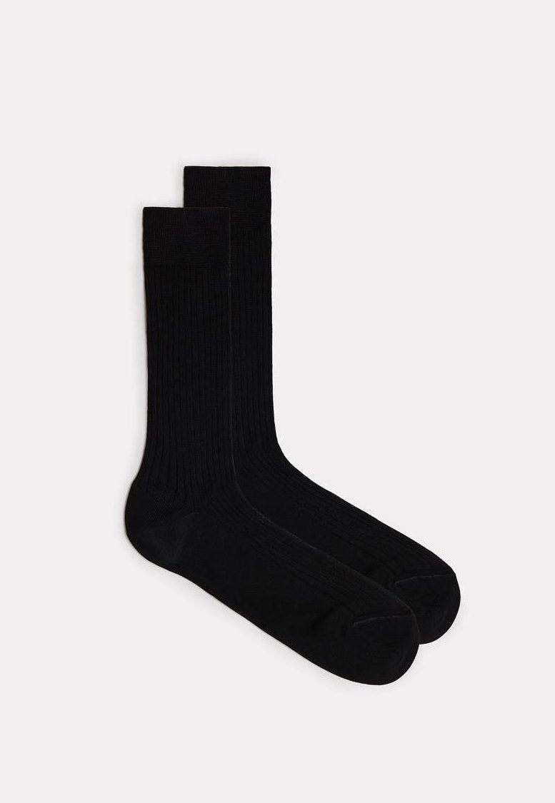 Sorte ribbede sokker med en glat tekstur, knæhøjt design og forstærket tå. Minimalistisk æstetik uden synlige logoer eller mønstre.