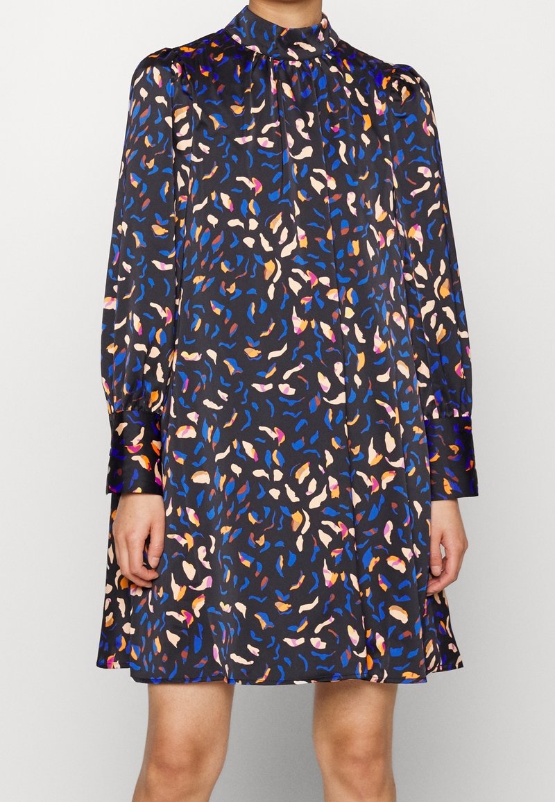 Sukienka w nadruk z ciemnym tłem i kolorowymi abstrakcyjnymi wzorami w odcieniach niebieskiego, różowego i pomarańczowego; długie rękawy i wysoki kołnierz.
