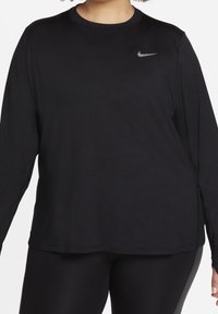 Czarna sportowa koszulka z długim rękawem wykonana z lekkiego materiału. Posiada okrągły dekolt i małe szare logo Nike na górnej lewej części klatki piersiowej.