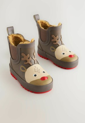 Botas de goma marrones con una cara de reno, nariz roja y cuernos; forro amarillo suave, suela roja texturizada y tira en la parte posterior.