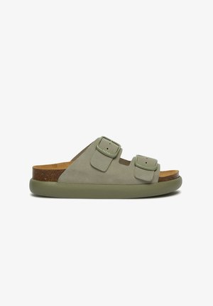 Green suede slide sandal with two adjustable straps, cork footbed, and rubber sole. Features smooth texture and minimalistic design.