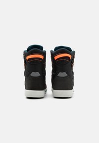 Sneaker alte con una tomaia in mesh e suede neri. Presentano dettagli arancioni vivaci, colletto imbottito e suola in gomma bianca.