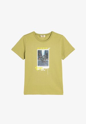 Kortærmet olivengrøn t-shirt lavet af bomuld. Har et grafisk tryk med tekst og et foto af en skateboarder på forsiden.