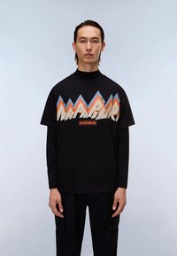 Melna T-krekls ar kalna grafiku oranžā, zilā un krēmkrāsā. Tam ir apaļa izgriezuma kakla daļa un garas piedurknes.